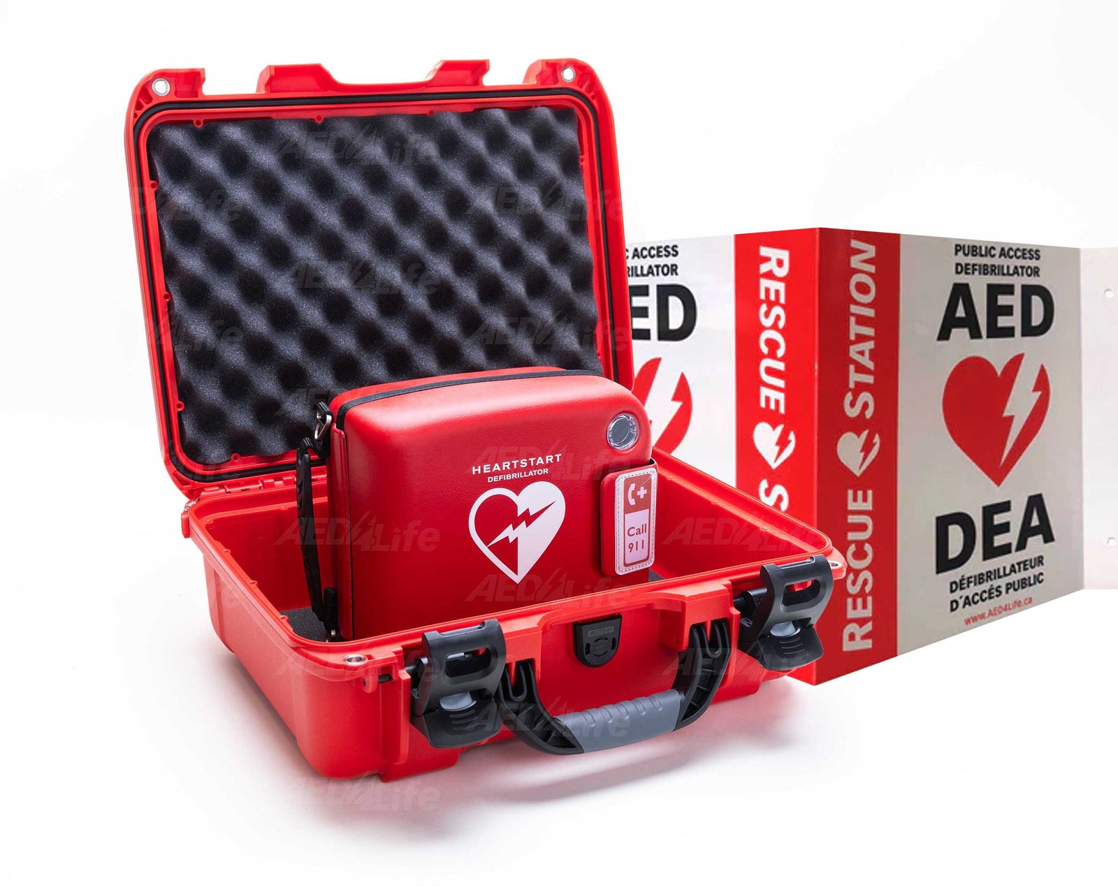 A red defibrillator case is open, displaying the Philips Heartstart FRX Grab & Go AED Bundle by The AED Shop, placed next to a rescue station sign with AED symbols.