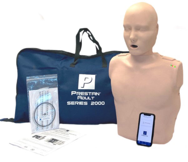 CPR training manikin with a phone, instruction papers, equipment, and a blue Prestan Adult Series 2000 bag.