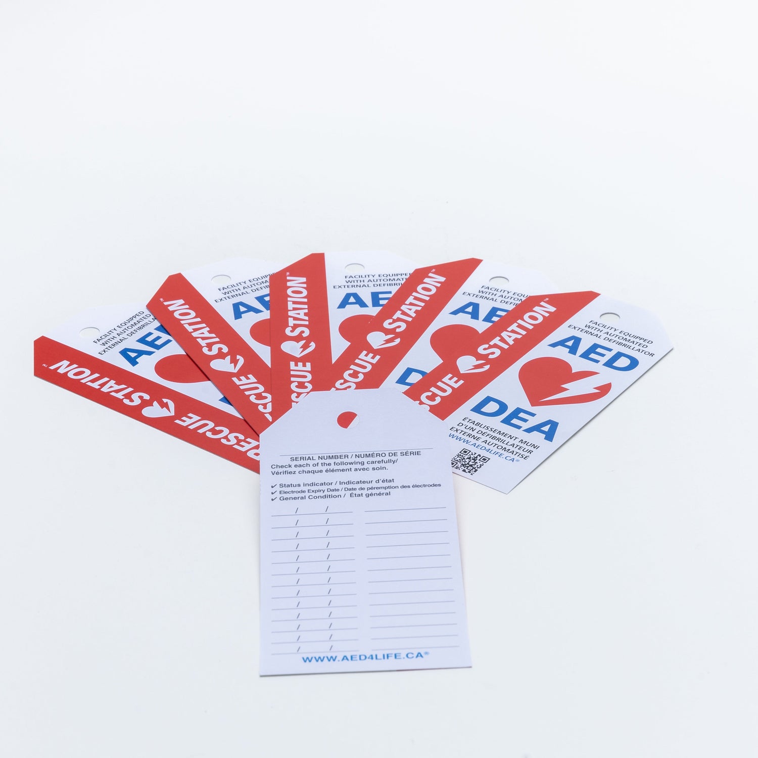 An AED Shop Inspection Tag set of 5 is fanned out on a white surface, prepared for delivery via Canada Post.