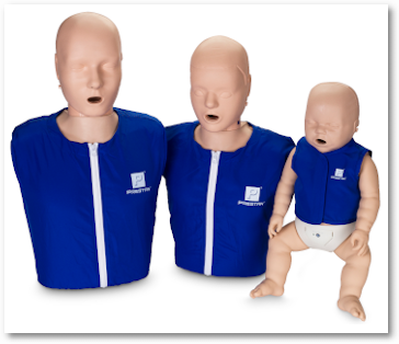 Three CPR training mannequins: two adults and one infant, all outfitted in Prestan manikin shirts from the Adult/Child 4-Pack, featuring blue fabric with white front zippers.