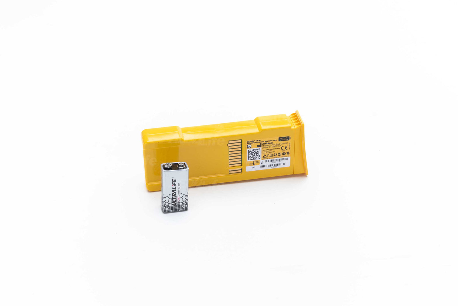 Defibtech lifeline AED battery with 9 volt battery against a light background. This replacement battery pack (DBP-2800) has a standby life (installed in the unit) of 7 years (including daily, weekly, monthly and quarterly self-tests), 300 defibrillation shocks, or 16 hours of continuous operating time.