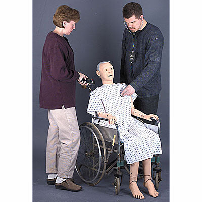 Two individuals interact with the Geri Auscultation Manikin from AED Shop, seated in a wheelchair and designed to simulate an elderly appearance for realistic patient care scenarios.