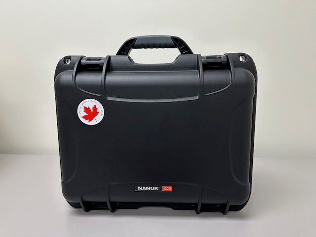 AEDShop's AED Hard Shell Case in black comes with a handle and offers ultimate protection. It features a sticker of a red maple leaf and a white circle on the upper left corner. This impact-resistant, waterproof case ensures your items stay safe in any environment.