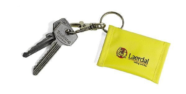 Two silver keys on a ring attached to a yellow Laerdal Face Shield Key Ring, emblazoned with the company logo and text, ideal for CPR training courses.