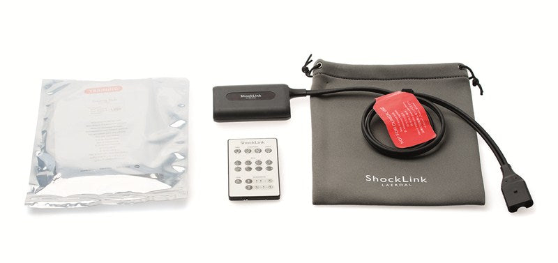 The ShockLink System by Laerdal for defibrillator training features a remote, receiver, wire, instructions, and pouch on a white background. Perfect for use with manikins, this system provides comprehensive and effective emergency response practice.